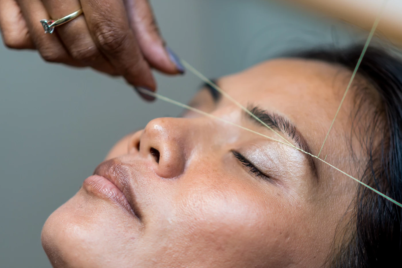 A woman having her eyebrows threaded at a salon