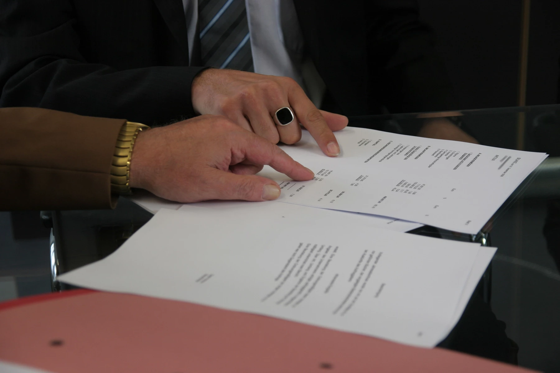 Two people going through contract documents at a desk