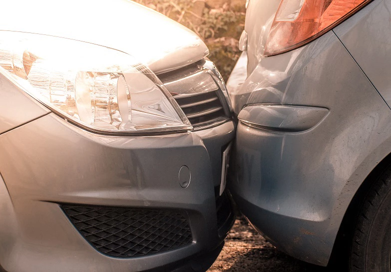 A car lightly hitting the car in-front in traffic