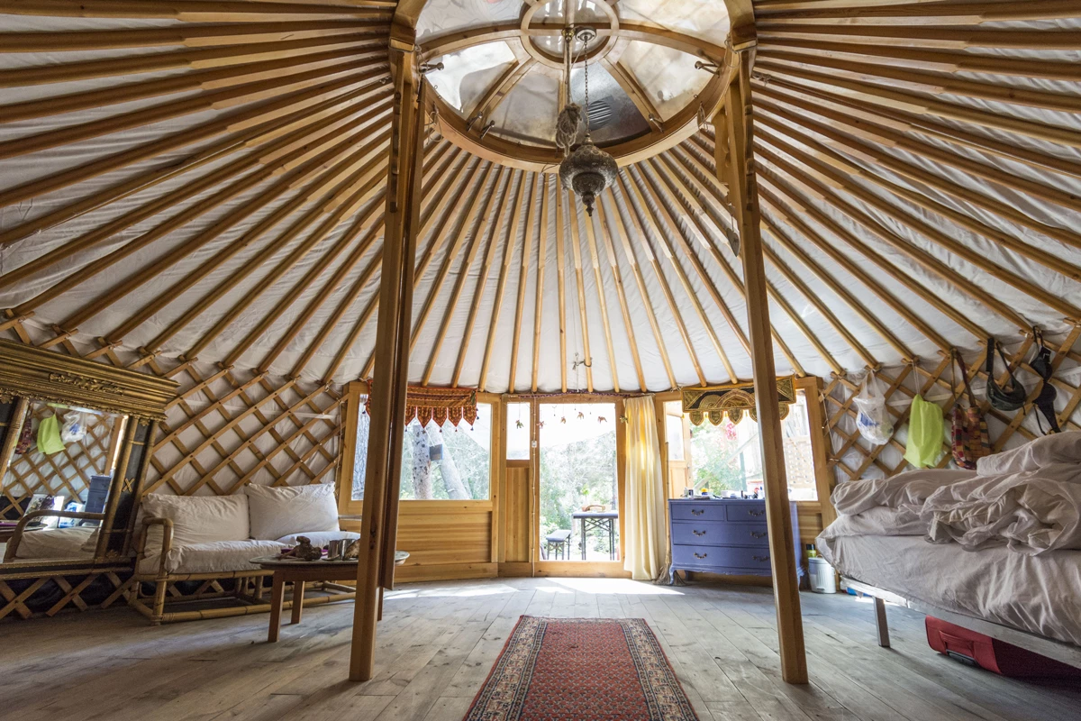 The inside of a yurt nicely furnished