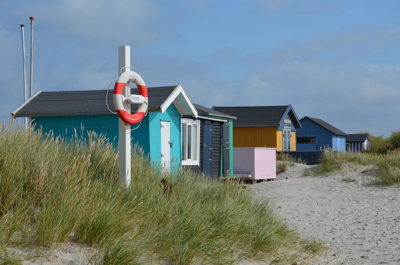 Colourful beach huts on a sandy beach on Aero Island