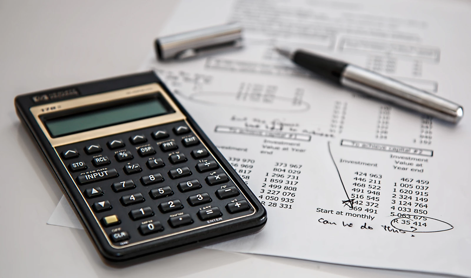 A calculator next to a sheet of accounting figures