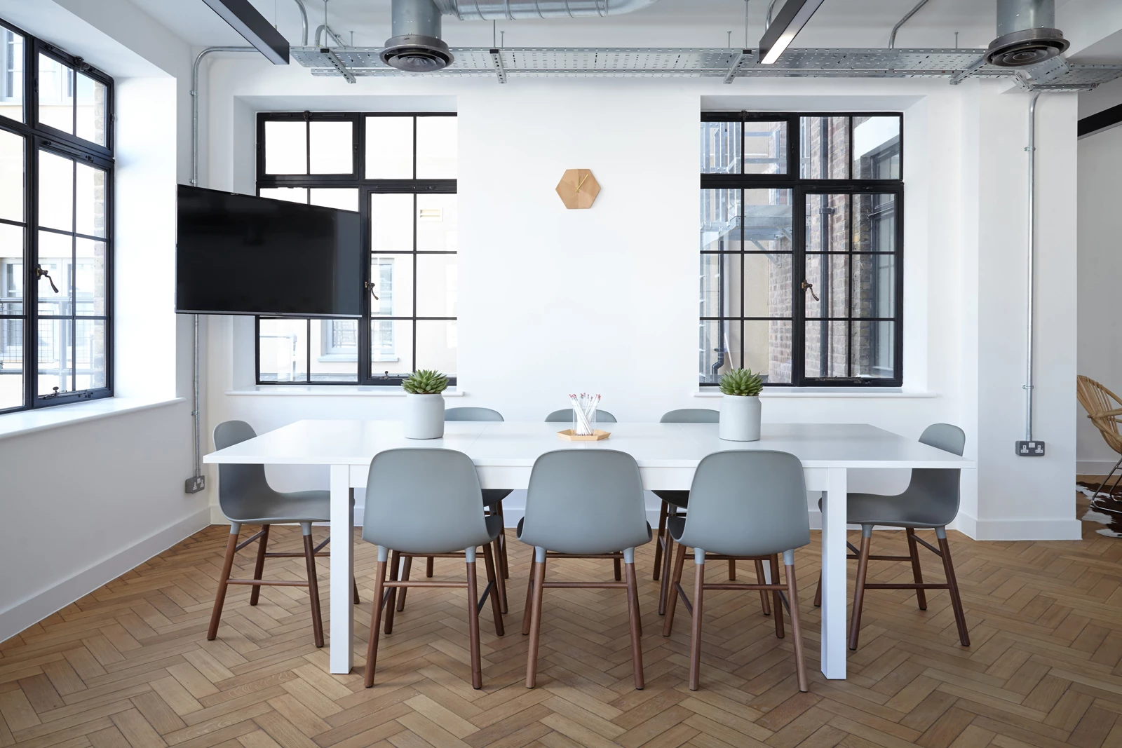 A dining area in an office with a table, chairs, and tv