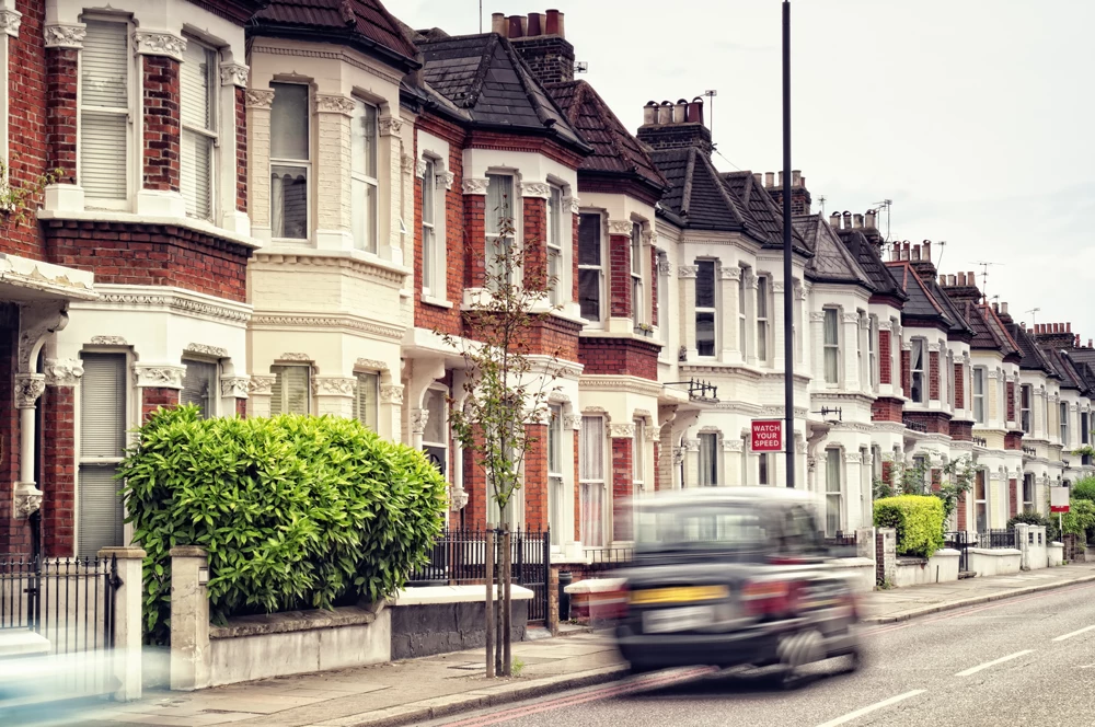 A row of terrace housing with a to let sign in the front garden of one