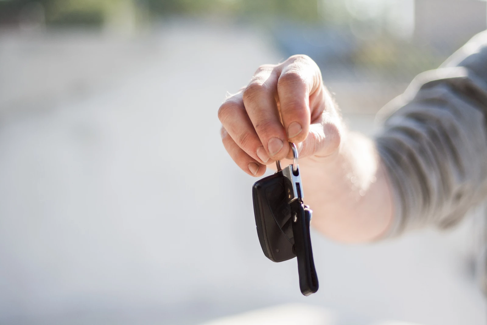 A garage worker handing the keys of a car back to a car owner