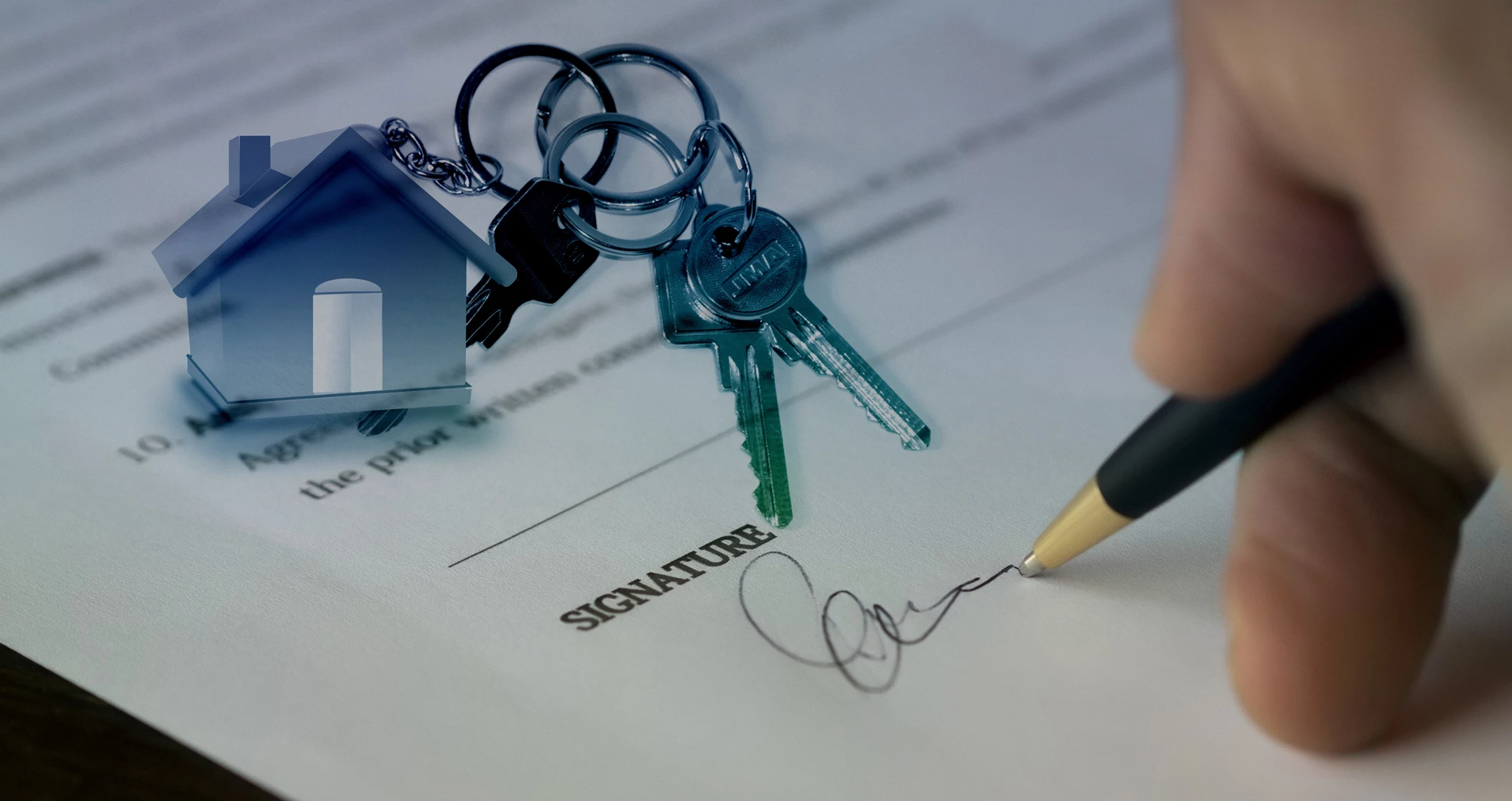 A person signing a document to buy a new property