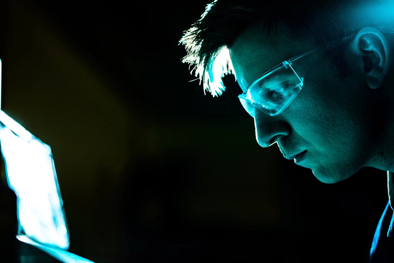 A gas engineer with safety glasses on working in a dark room