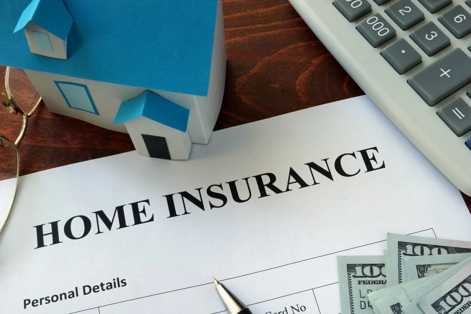 A home insurance document under a model house on a table