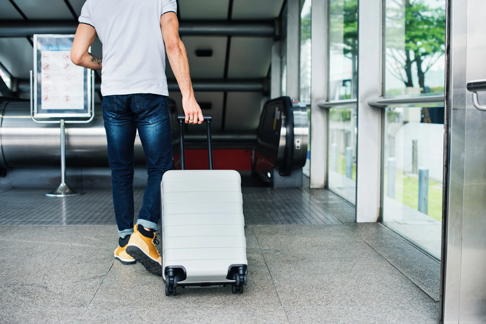 Man walking through airport with suitcase