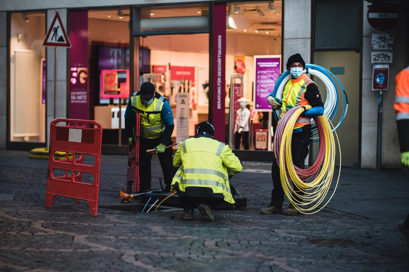 Workers laying fibreoptic wire on a paved city street