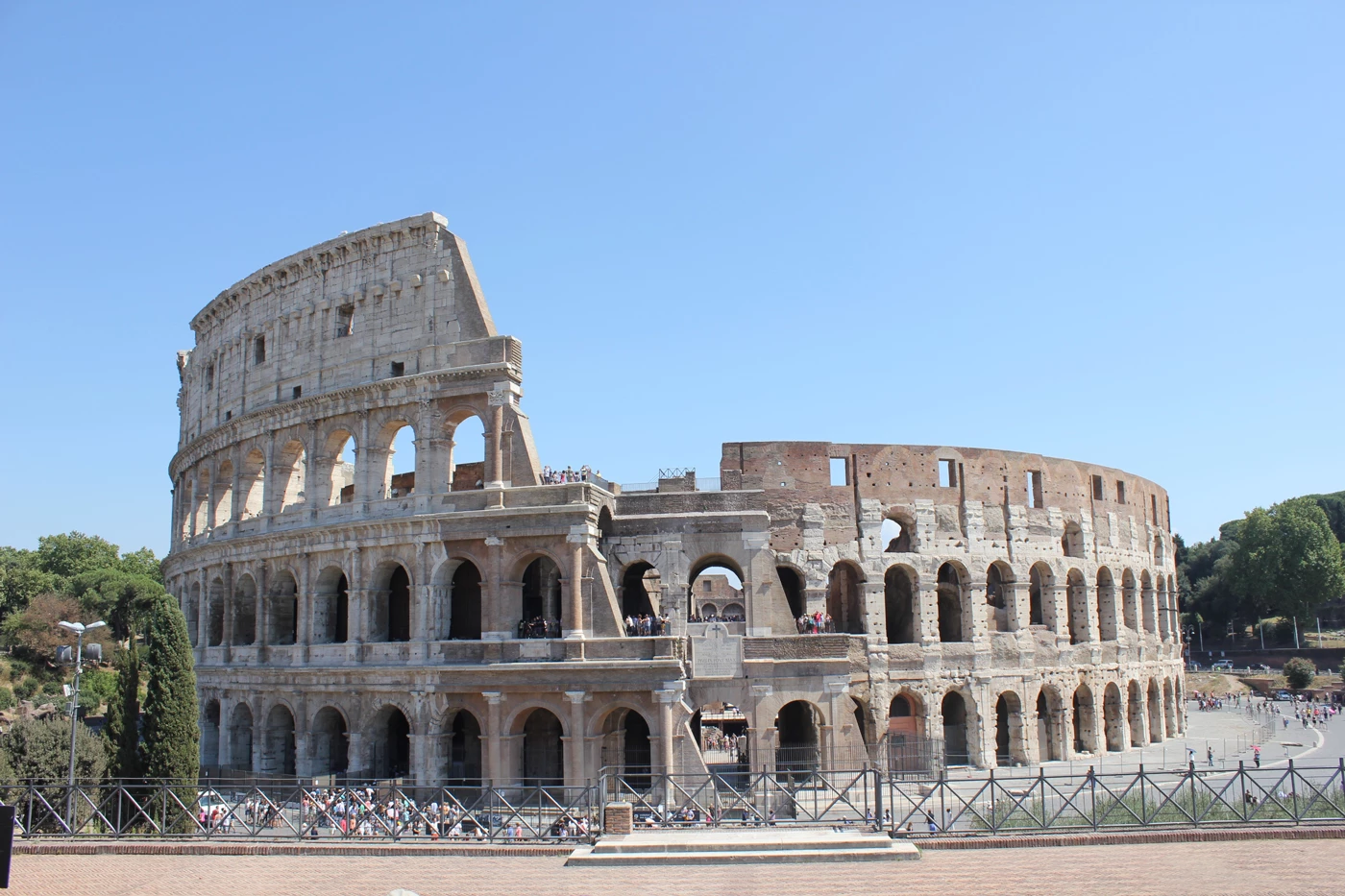 The Roman Colosseum on a sunny day with many tourists looking round it