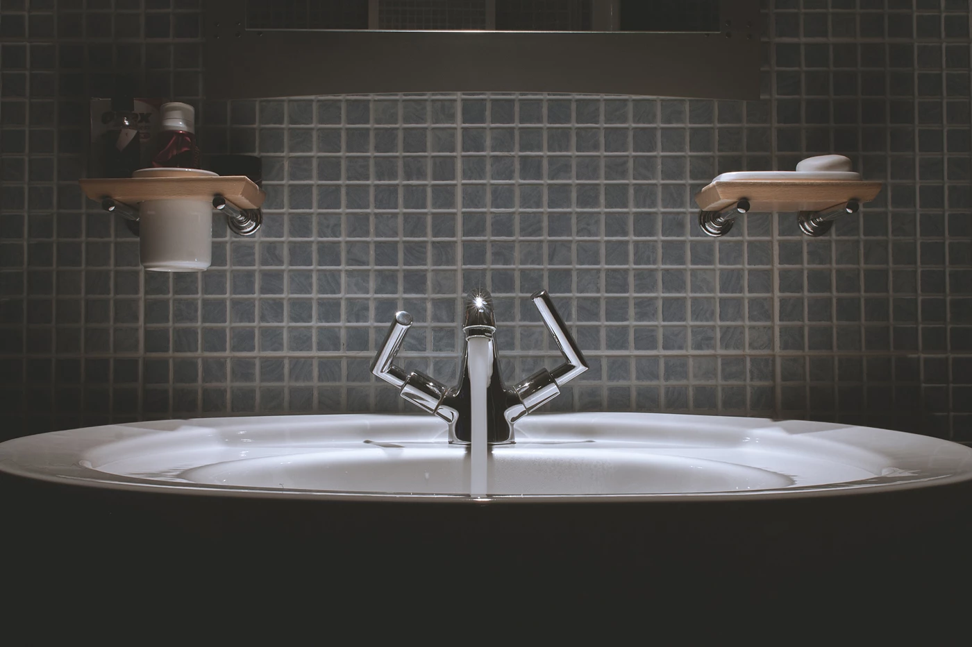 A sink in a bathroom with the tap left running