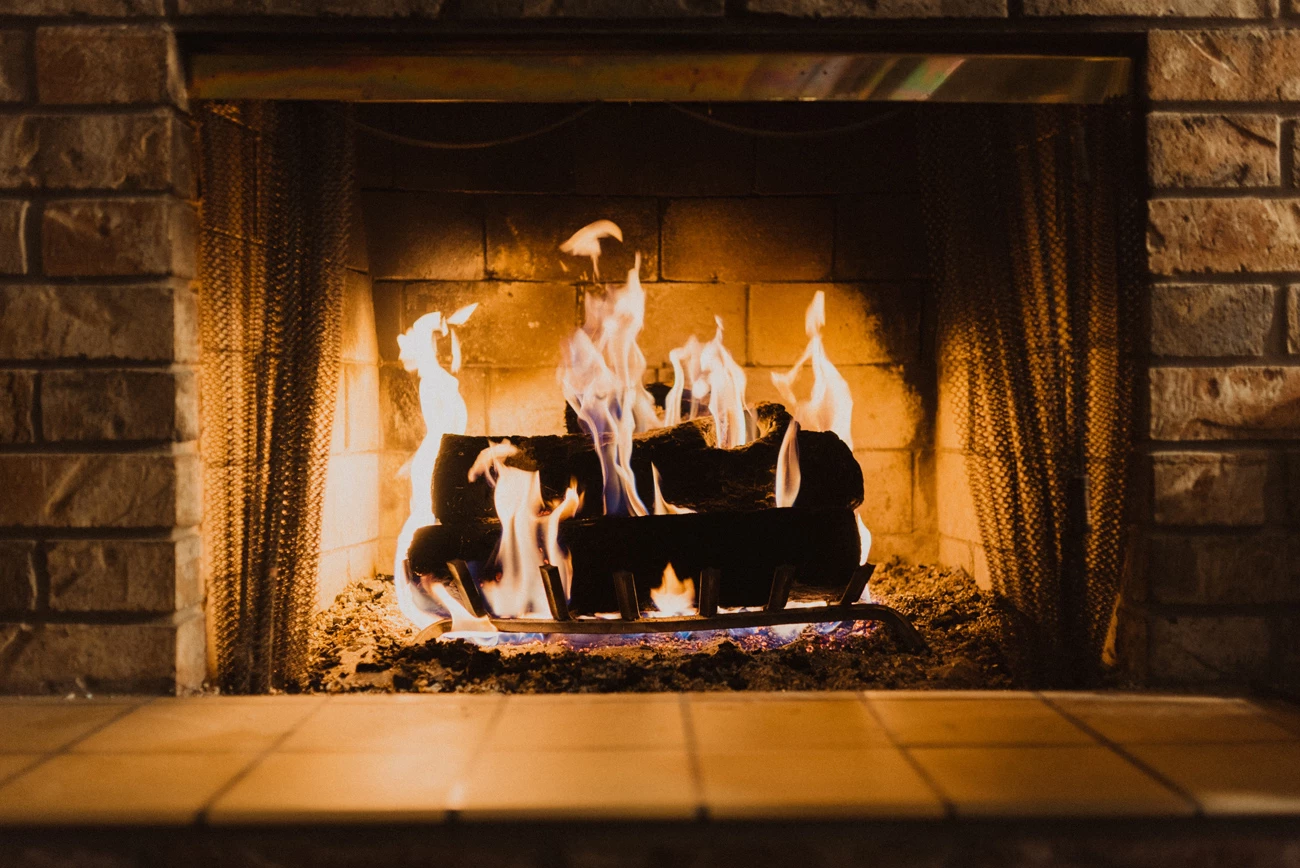 A log fire lit in a fireplace in a holiday home