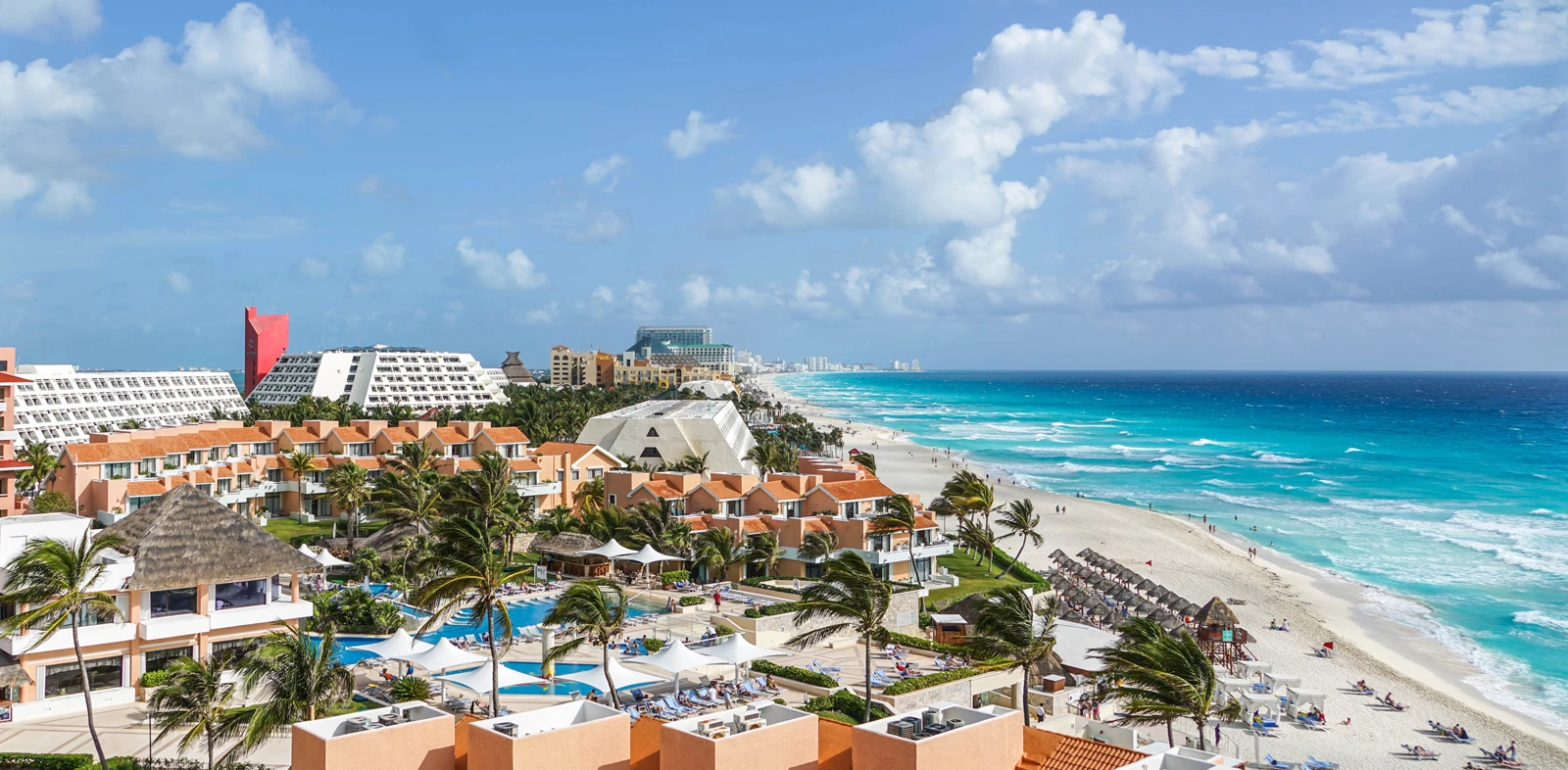 A view over a large resort in Cancun, Mexico, on the sandy shoreline on a clear sunny day