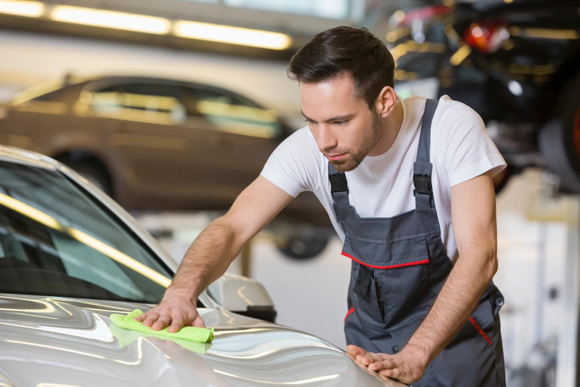 An MOT tester wiping down a car he has just tested