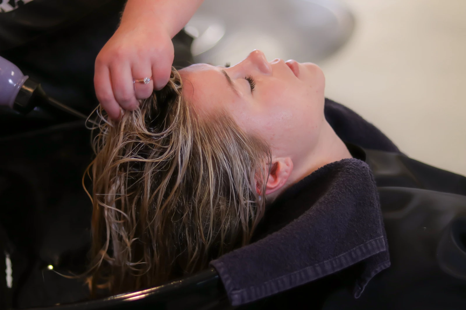 A hair dresser drying a woman's hair after a wash at a salon