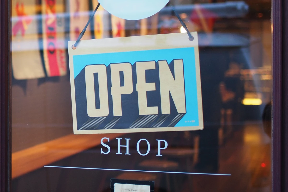 An open sign pinned up on a glass door