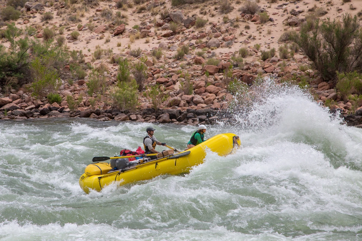 A yellow raft tackling the white water rapids at the Grand Canyon