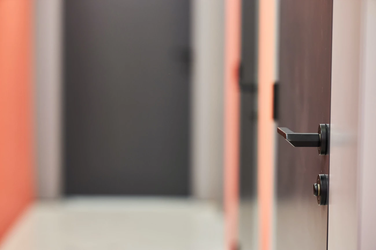 A door with an empty corridor next to it in an unoccupied house