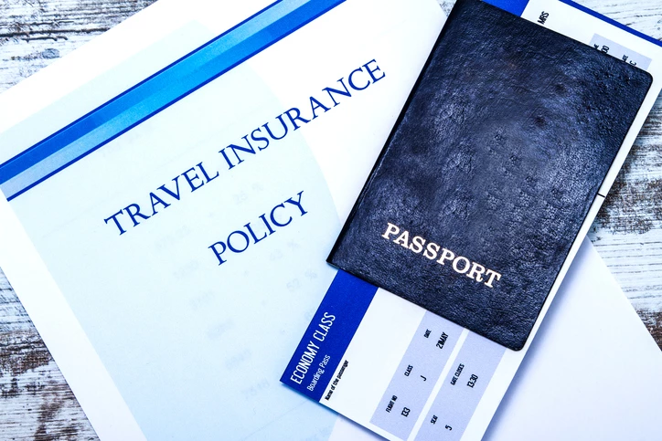 A passport sitting on top of travel insurance policy documents