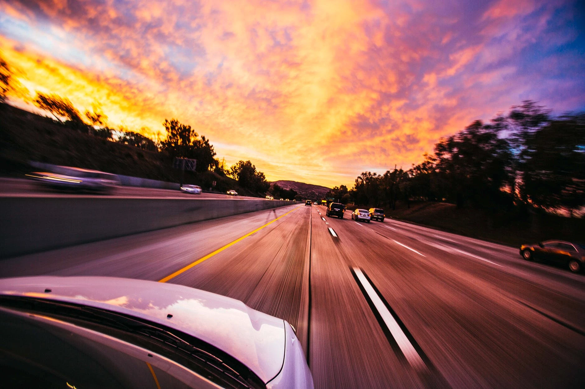 A car speeding on a motorway at sunset