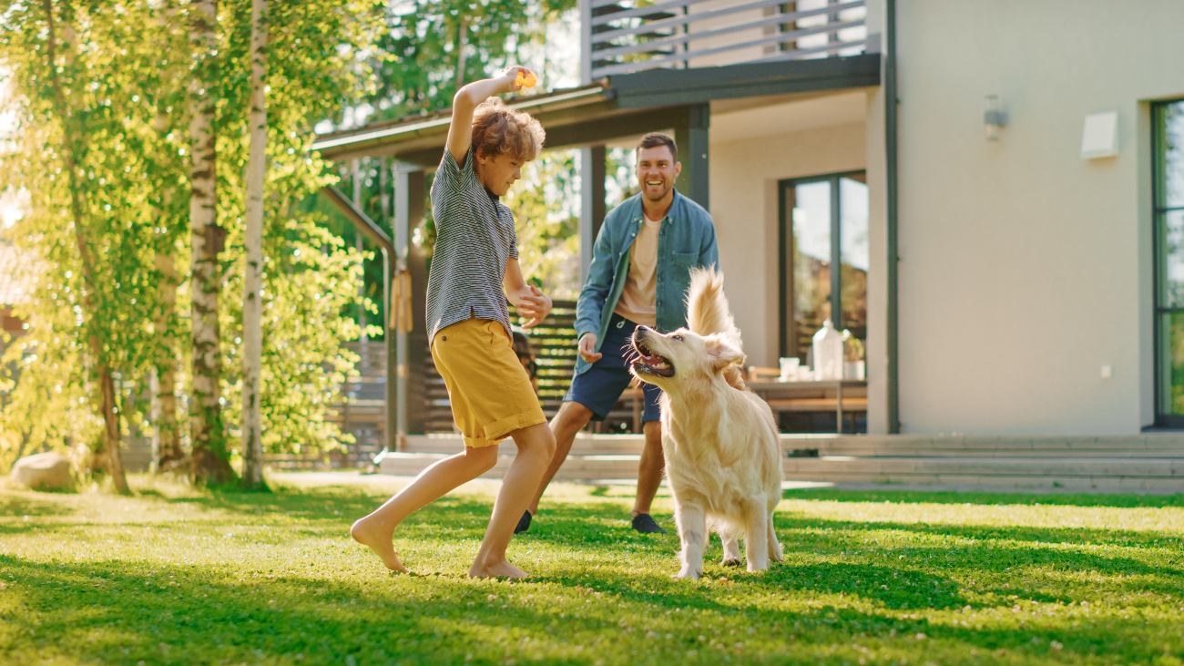 A Family Playing With A Dog In The Garden