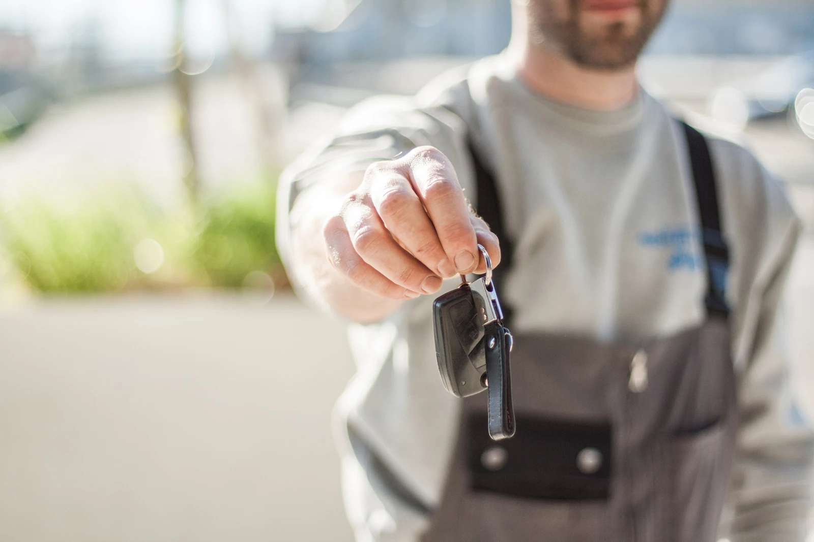 A mechanic holding up the keys to a customers car