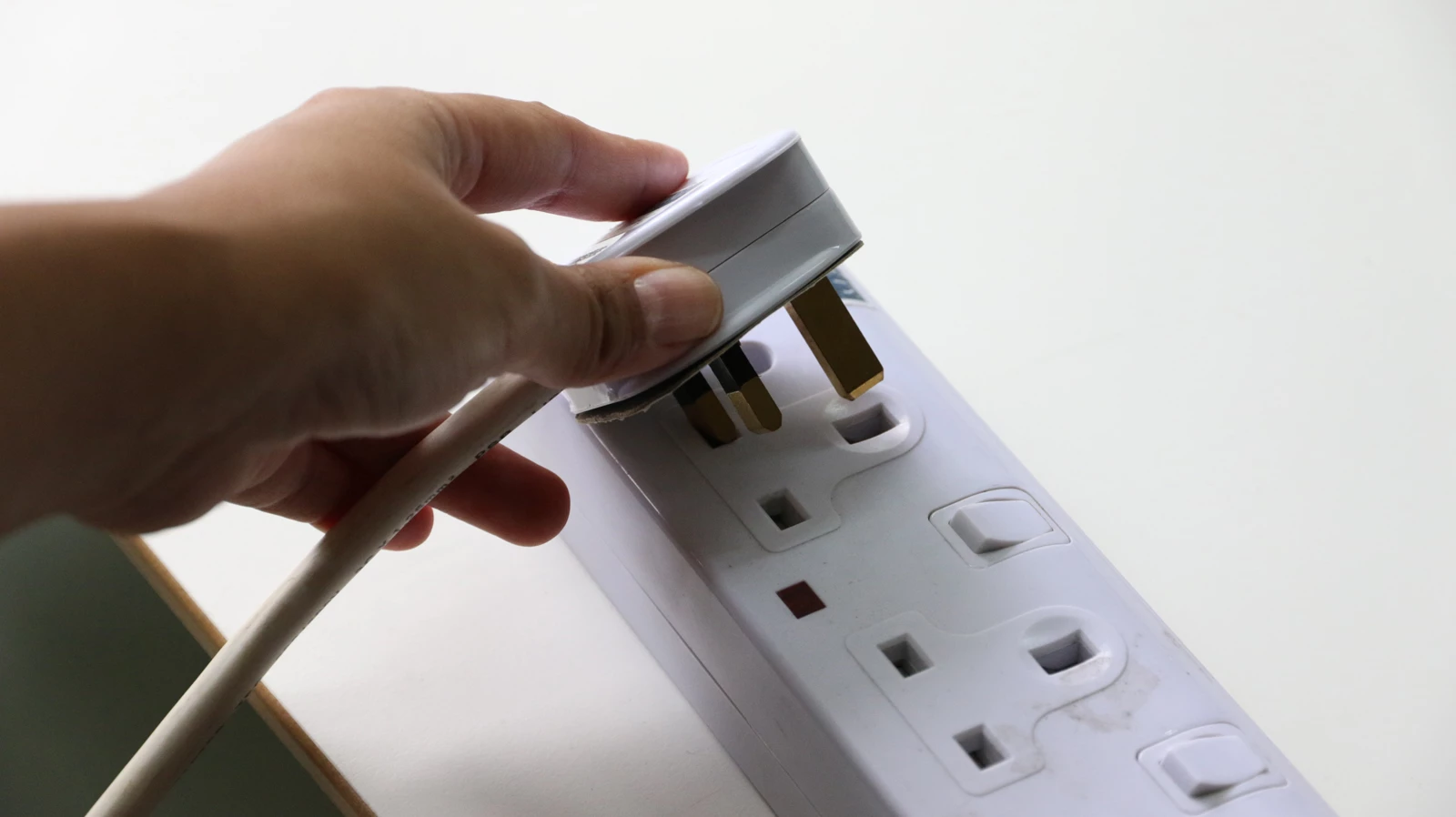 A person plugging an appliance into a multi-plug socket
