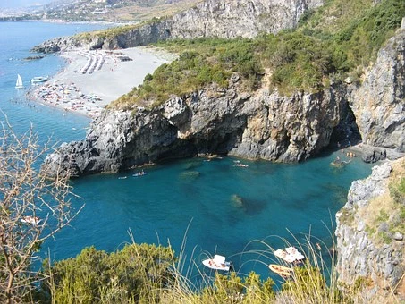 A view over a cliff into a clear watered bay in Calabria, Italy.