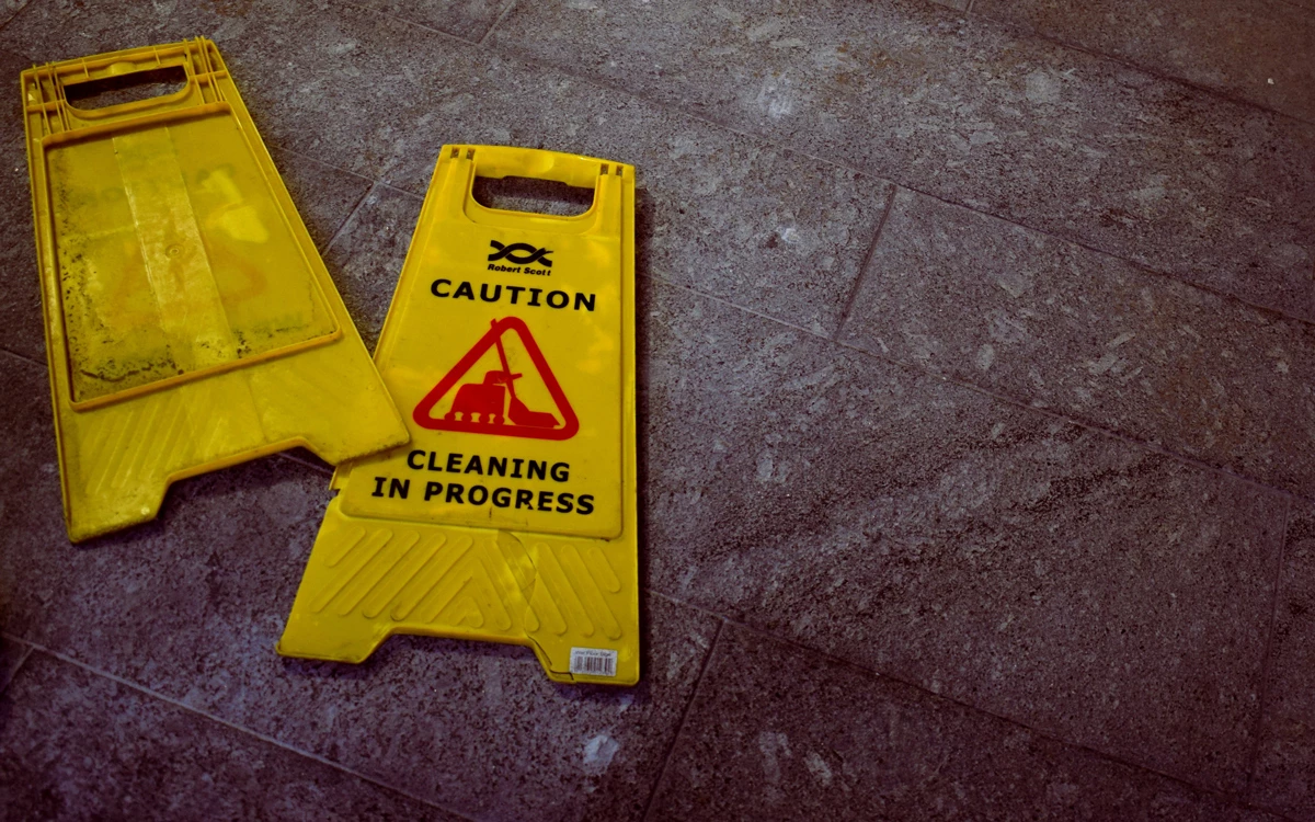 A wet floor sign broken and laid on the wet floor