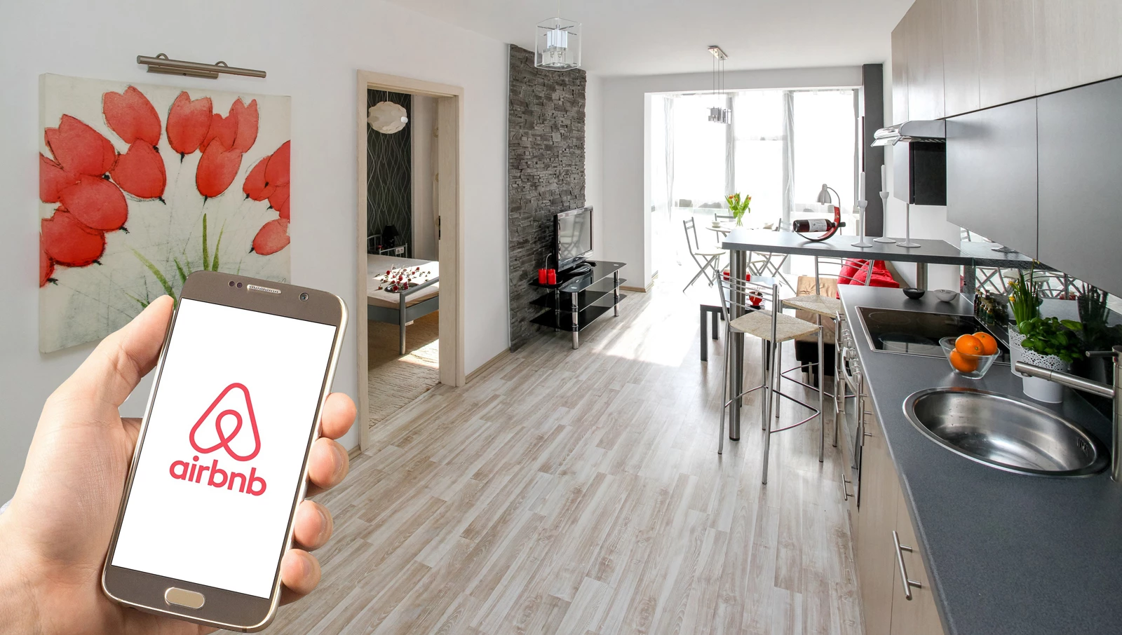 A person holding a phone with the airbnb app opening on it inside an airbnb room