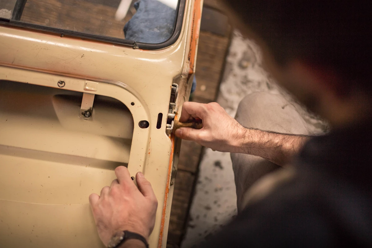 A man manufacturing a car door in a factory 
