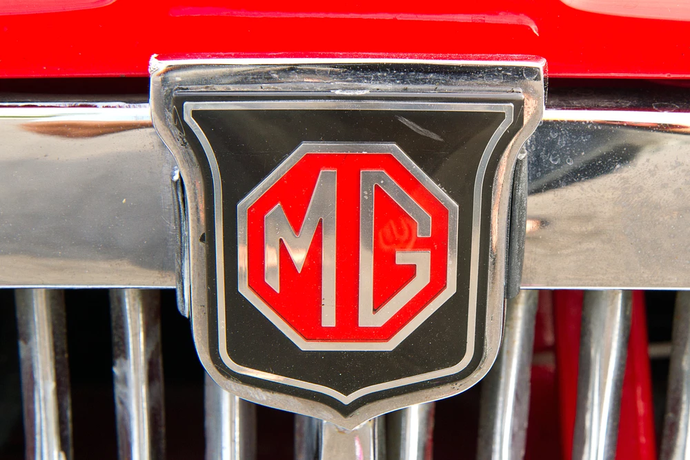 The badge of a classic MG on the grill of the car 