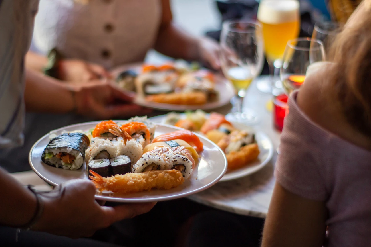 A waiter taking a plate of seafood out to a table