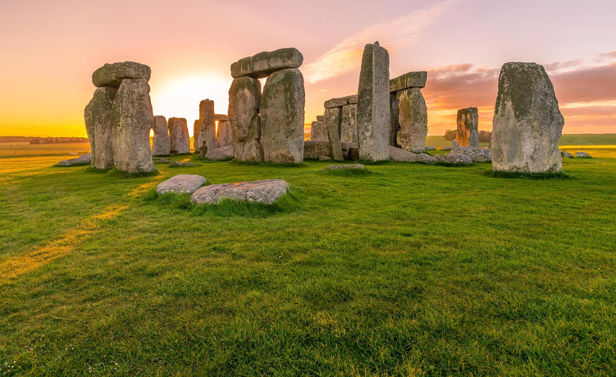 Stone Henge with the sun setting behind the large stones