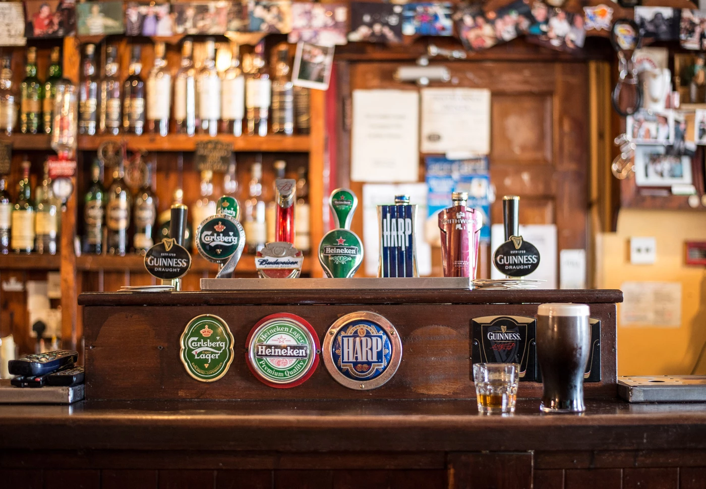 A bar in an English pub with various beers on tap