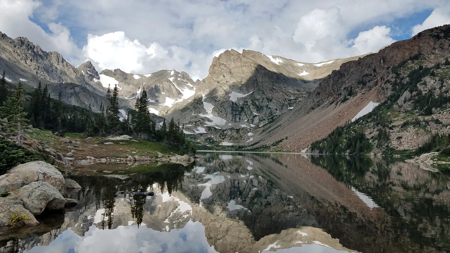 Large snowy mountains in the Rockies with a clear, reflective lake in between. Denver, Colorado