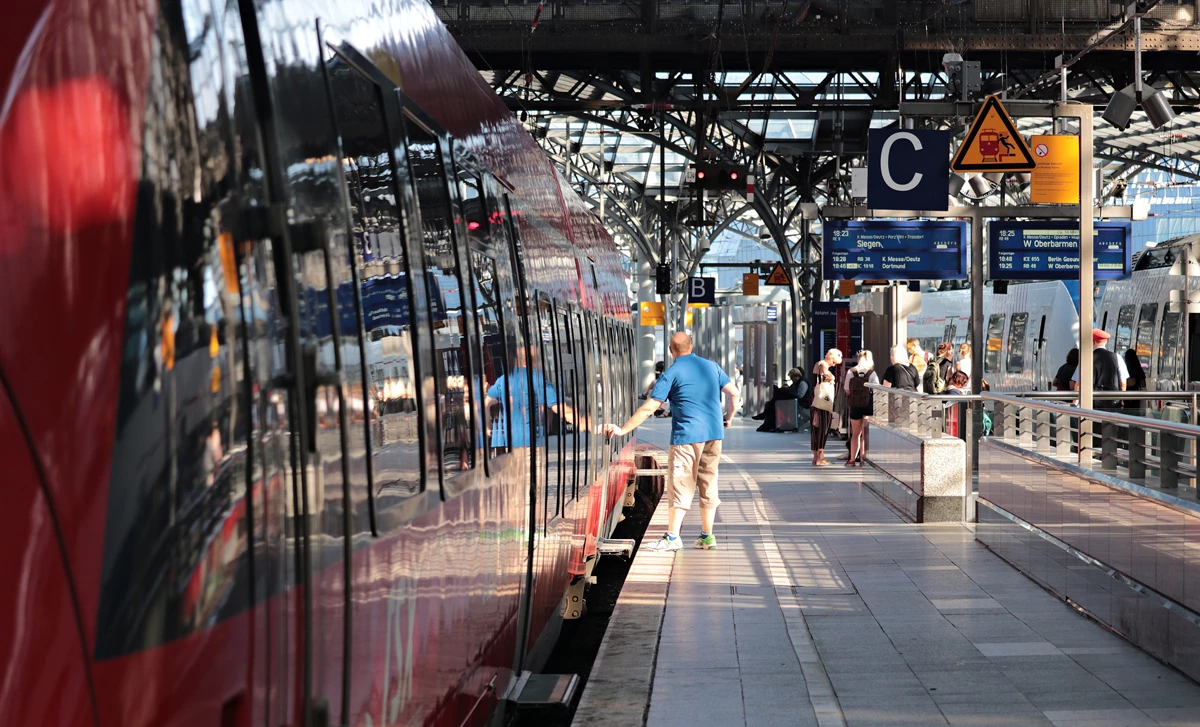 A busy train station in Europe with a train at the platform