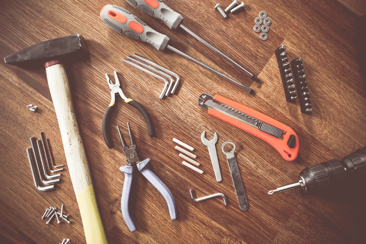 Various construction tools laid out on wooden flooring